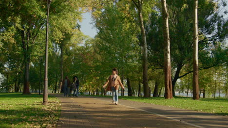 행복 한 가족 은  ⁇ 은 따뜻 한 저녁 에 함께 공원 에서 산책 한다. 즐거운 소녀 가 점프 한다