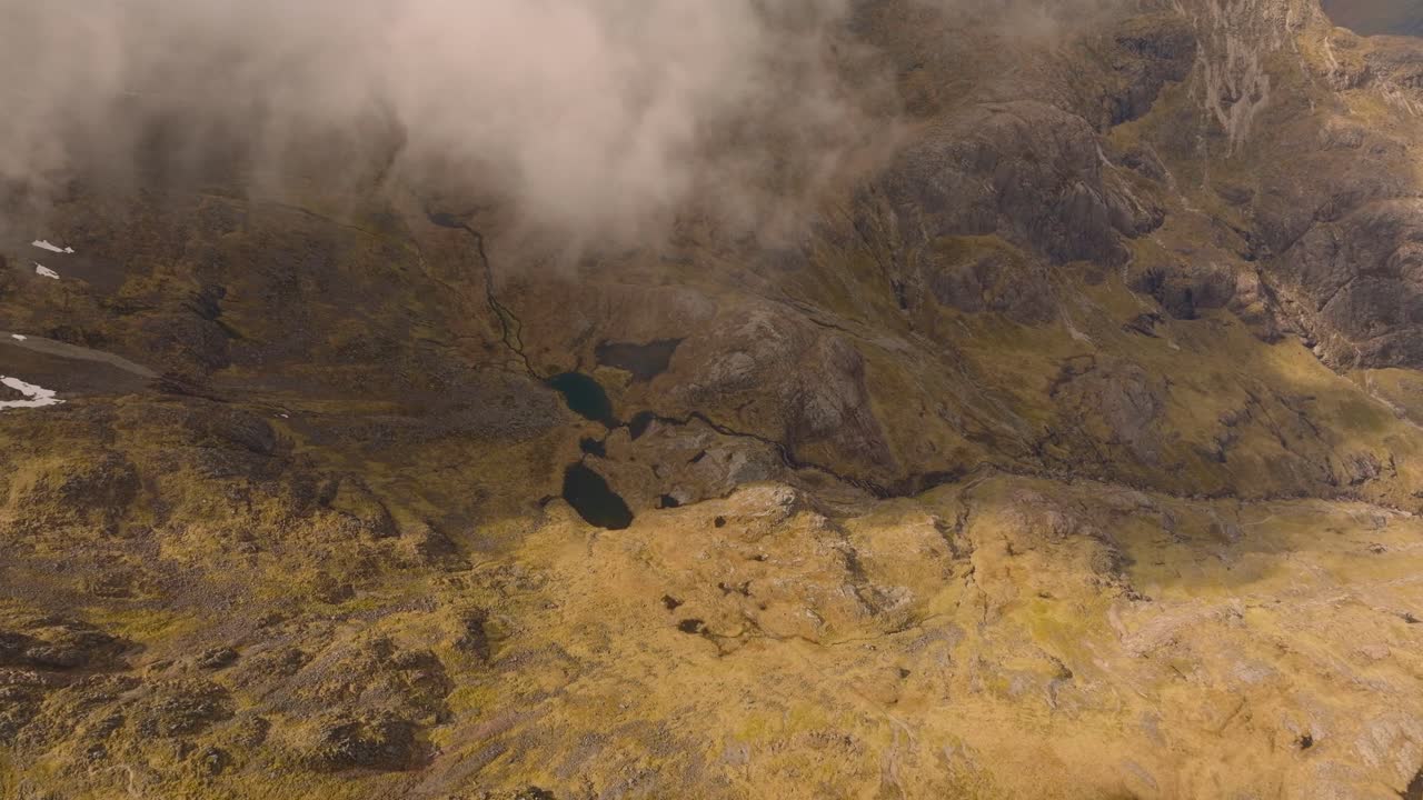 Aerial drone footage of Bidean Nam Bian, the highest mountain in Glencoe, Scotland, covered in snow. Sweeping views of snowy peaks, deep valleys, and dramatic Highland scenery