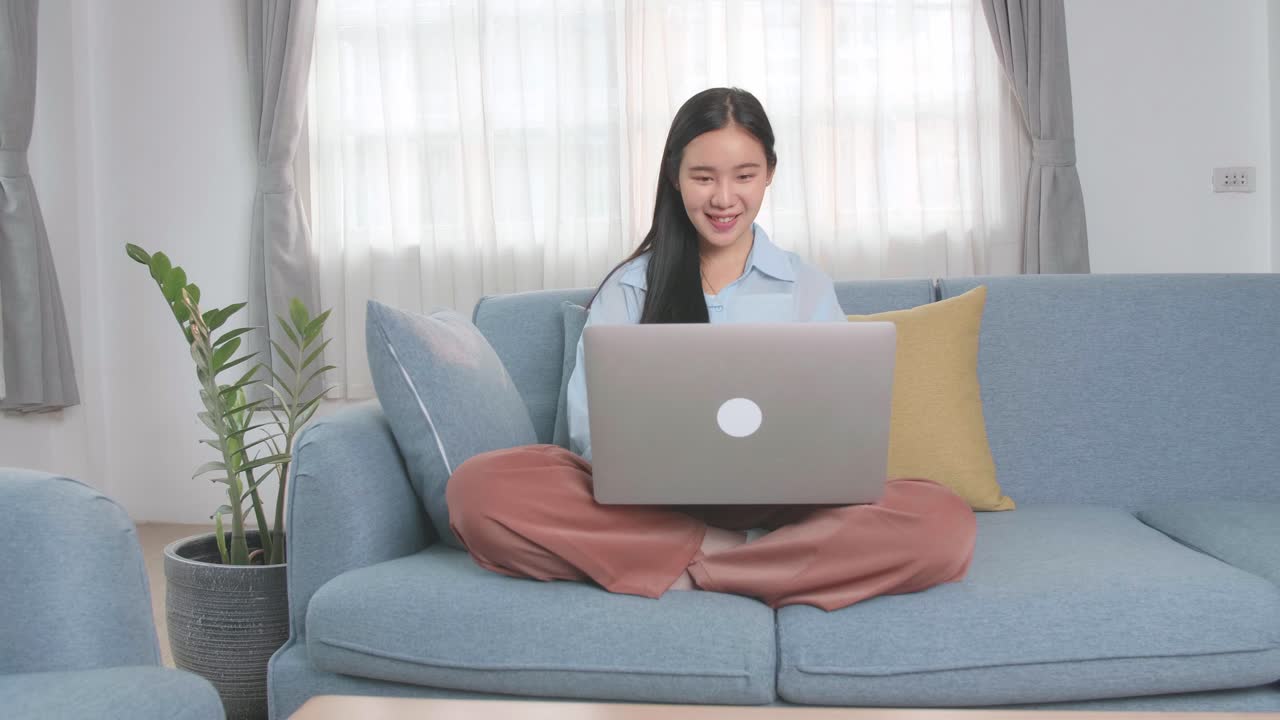 Asian Woman Sitting Sofa And Use Laptop Computer In Home Living Room, Video In 4K