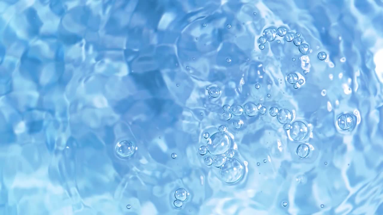 白い背景に水面に落ちる滴と発散円の上面図のスローモーション