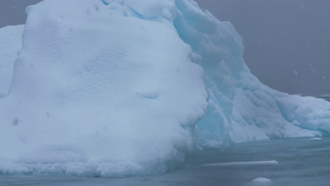 Snowy-Day-on-Antarctica,-Close-Up-of-Iceberg-in-Cold-South-Pacific-Ocean-Water