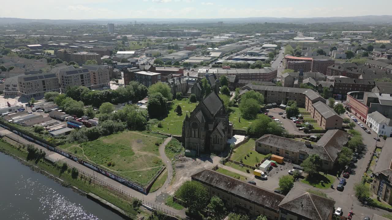 Aerial orbit around historic Govan Old Parish Church with Govan district in the background, Glasgow, Scotland, UK