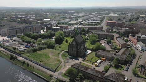 aerial orbit around historic govan old parish church with govan district in the background, glasgow, scotland, uk