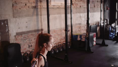 Cámara-Lenta-De-Mujer-Joven-Delgada-Haciendo-Ejercicio-De-Sentadillas-Con-Barra-En-El-Gimnasio