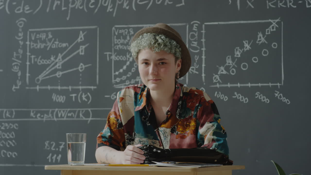 Student with Hat in Science Classroom with Blackboard Formulas