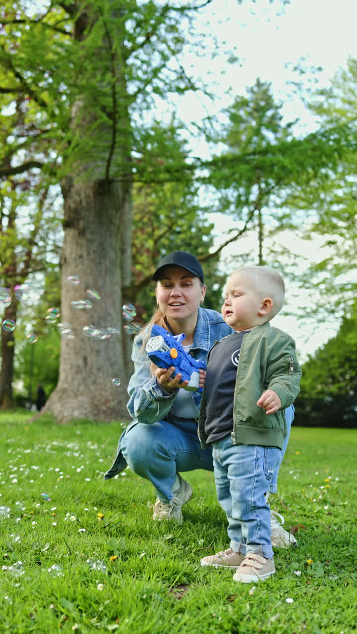 Madre felice a passeggio con il figlio al parco. La mamma gioca con il figlio al parco giochi all'aperto. Tempo della mamma con il figlio. Maternità felice.