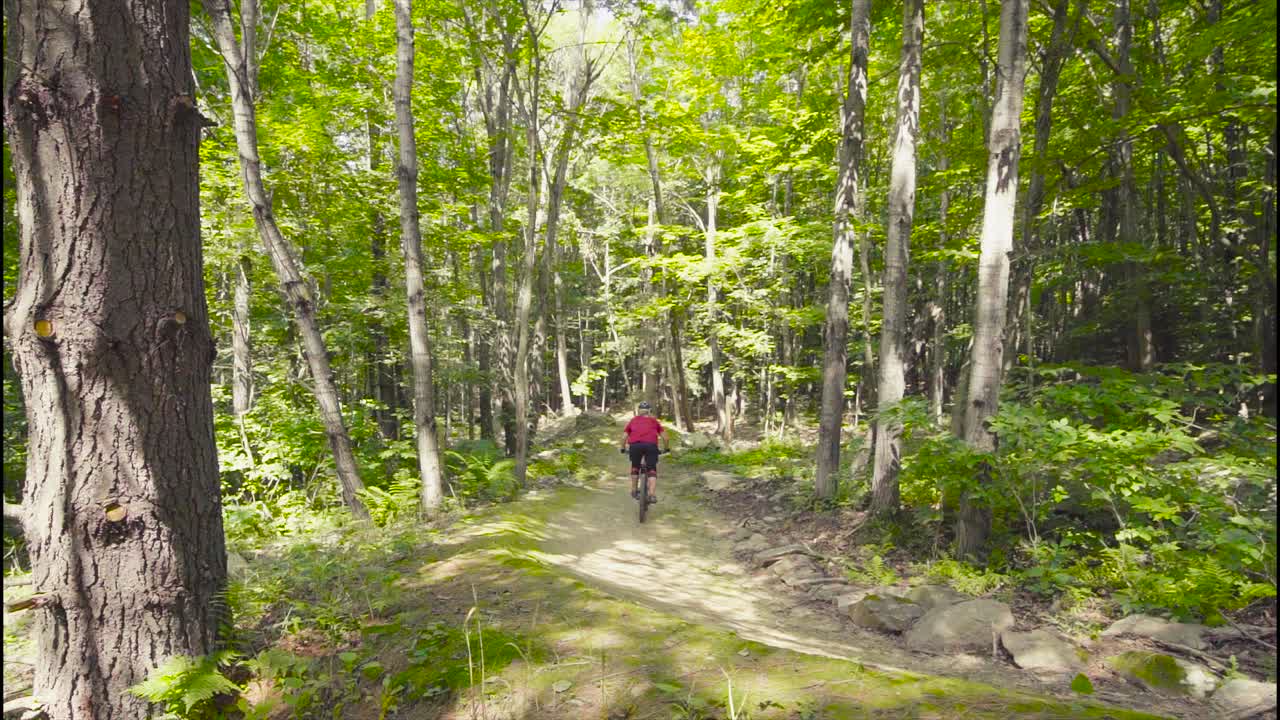 Slow motion footage of an Mtb rider zooming off a hip jump.