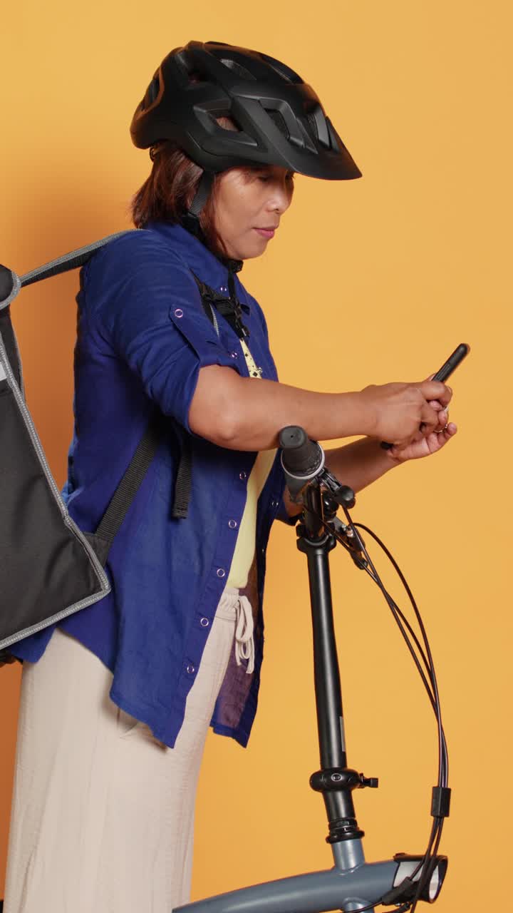 Woman with bicycle looking at mobile phone