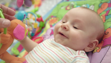 playful baby smiling on development mat