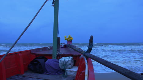 Bow-of-a-wooden-ship-with-sea-waves-in-the-background-in-blue-light,-Songkhla,-Thailand