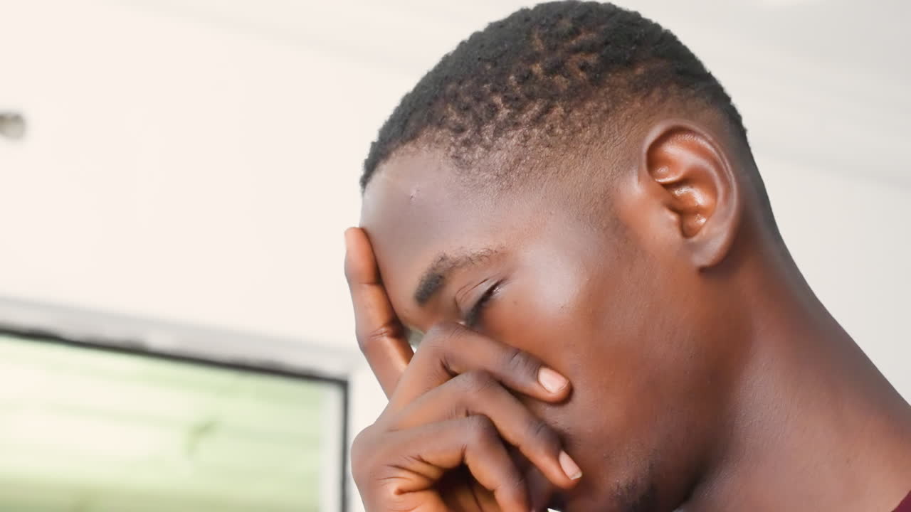 Black male near window pensive gaze, close portrait series showing thoughtful gestures, hand touching face, soft natural light, neutral interior, intimate mood shifts, student and thinker roles