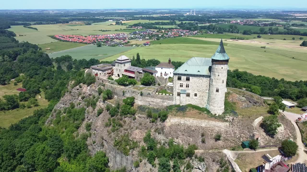 Drone panoramic establishing orbit of Kuneticka Hora Castle surrounded by Czech countryside under clear skies