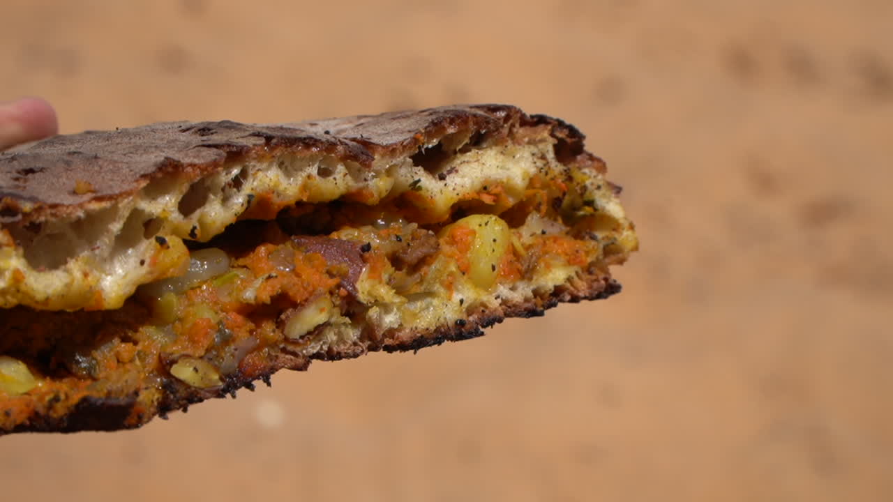 Indulge in the mouthwatering flavors of Tafarnoute, a traditional Moroccan Sahara bread, also known as the 'desert pizza