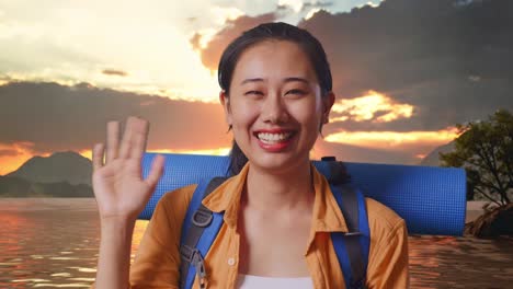 close up of asian female hiker with mountaineering backpack waving hand and saying bye while standing at a lake during sunset time