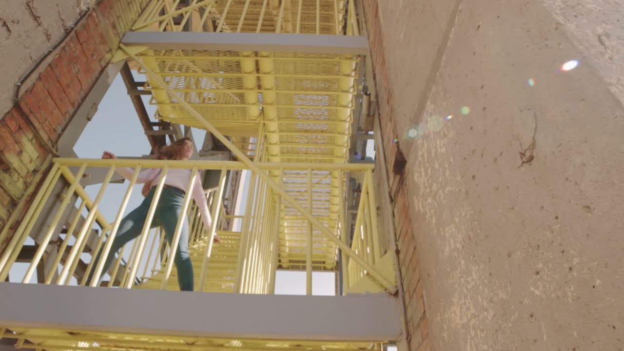 Woman Dancing on Industrial Stairwell Outdoors