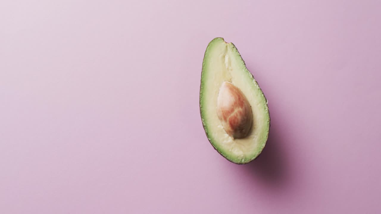 Video di avocado a fette con spazio per il testo su sfondo rosa