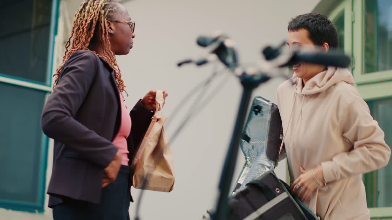 Food delivery exchange between courier and businesswoman