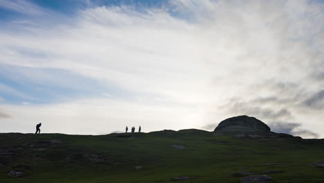 hikers on a hilltop at sunset