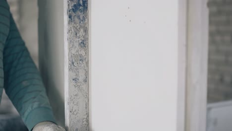 un trabajador de reparación cualificado alinea la pared de yeso blanco