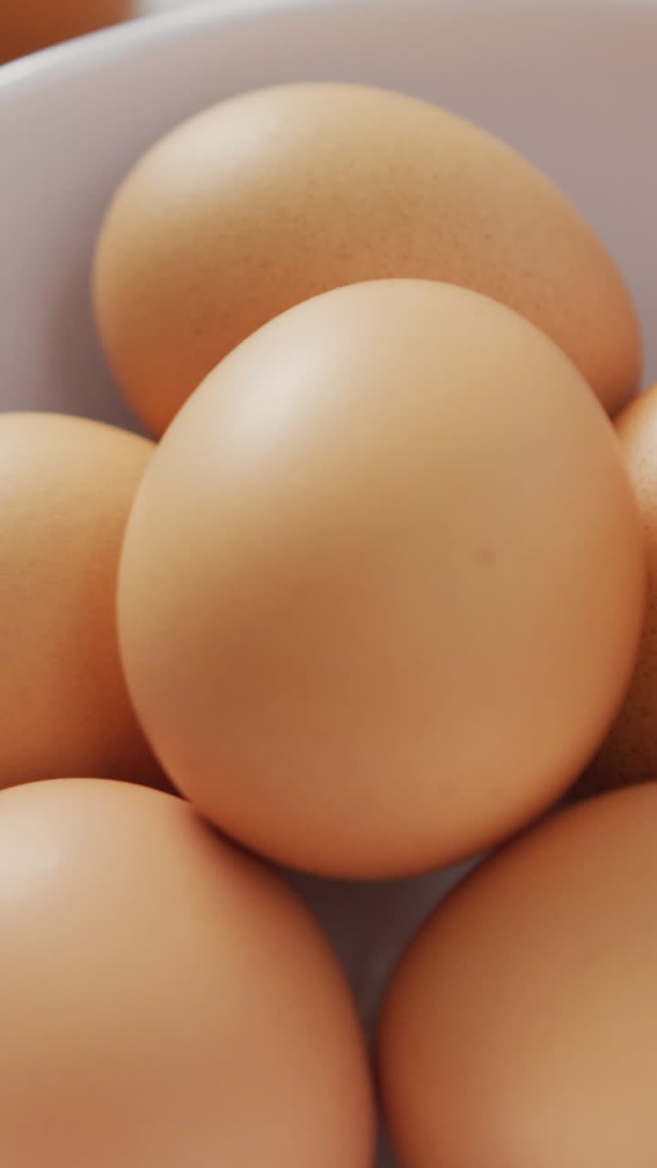 video di close-up di uova e frusta d'uovo su tessuto rustico su sfondo beige