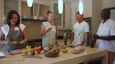 group of diverse friends preparing healthy meal together, laughing in modern kitchen, at home