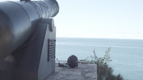 Old-historic-gun-on-top-of-mountain-with-wide-ocean-in-background