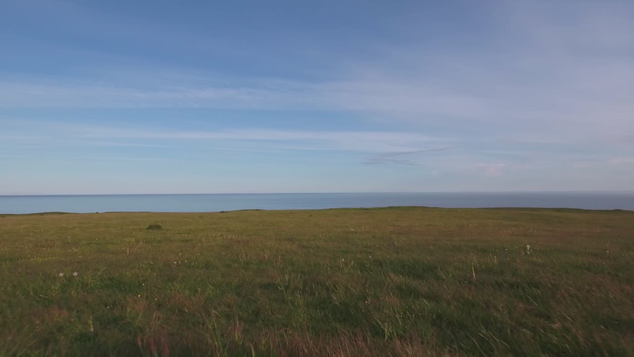 여름 저녁에 발트해까지 언덕 꼭대기에 있는 초원, 남쪽 스웨덴 skåne österlen kåseberga, ales stenar 근처, 지상에서 해수면에서 멀리까지 낮은 공중