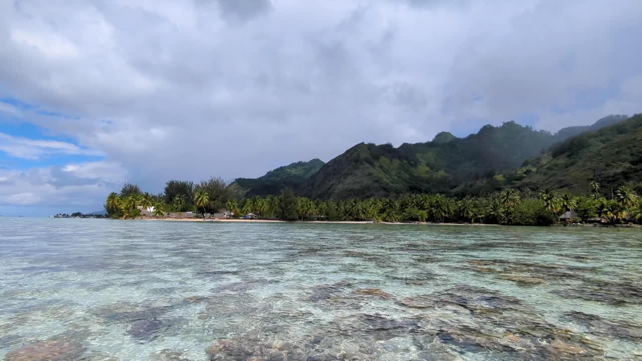 Scenic view of crystal clear ocean water and rugged tropical Moorea Island in French Polynesia