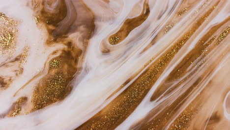 abstract swirls of gold glitter and brown fluid