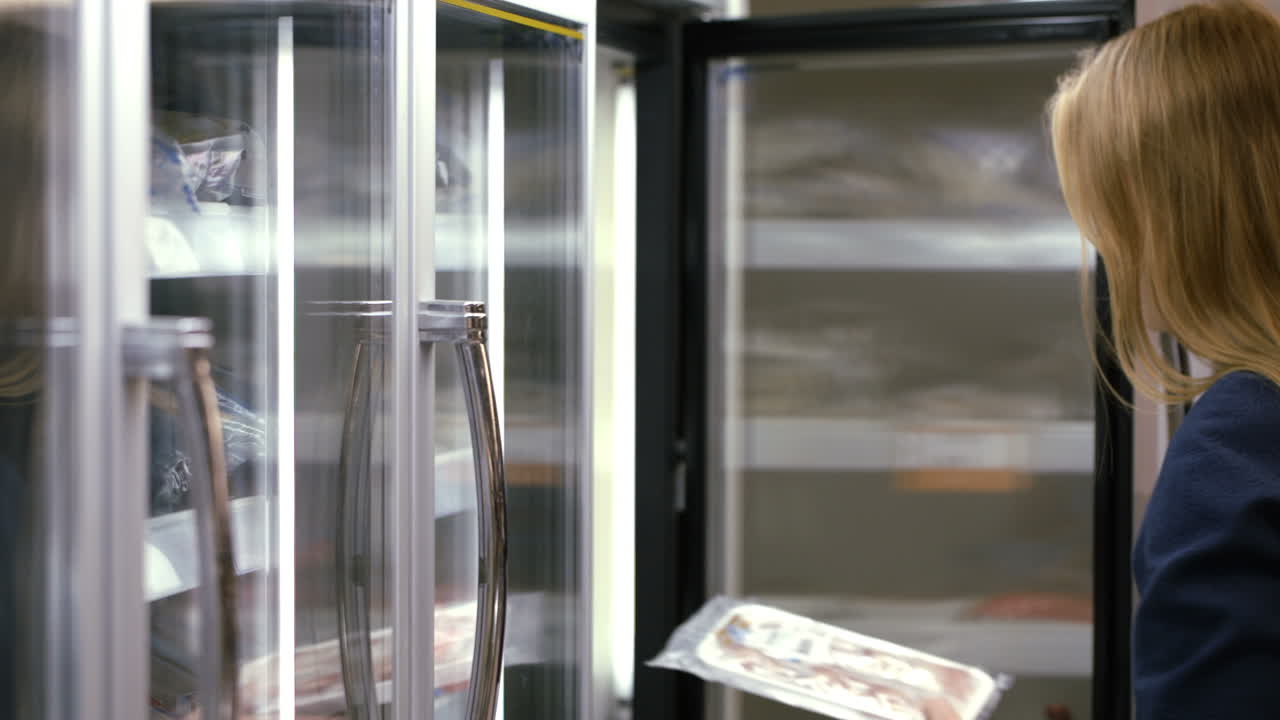 mujer tomando producto congelado del refrigerador en la tienda