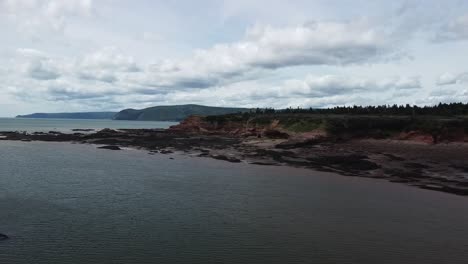 Disparo-De-Un-Dron-Sobre-La-Costa-De-La-Bahía-De-Fundy-Cerca-De-La-Playa-Junto-Al-Agua,-Nuevo-Brunswick