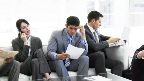 business people sitting on a sofa waiting in office