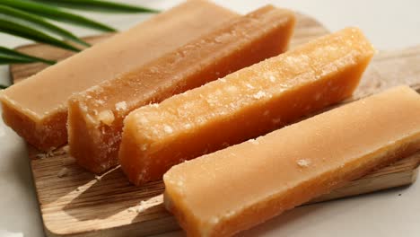 close-up of jaggery blocks on wooden board