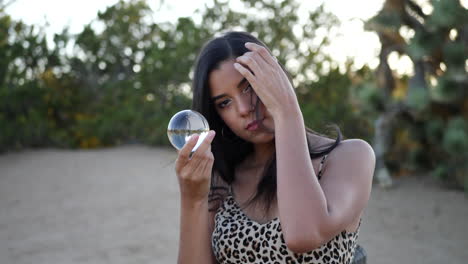 a gorgeous hispanic woman enchantress holding a magic crystal ball slow motion