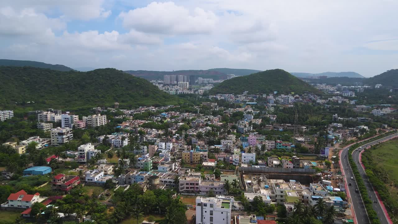 Breathtaking aerial drone shot of Vizag, where the city meets the ocean, with waves lapping against the shore.