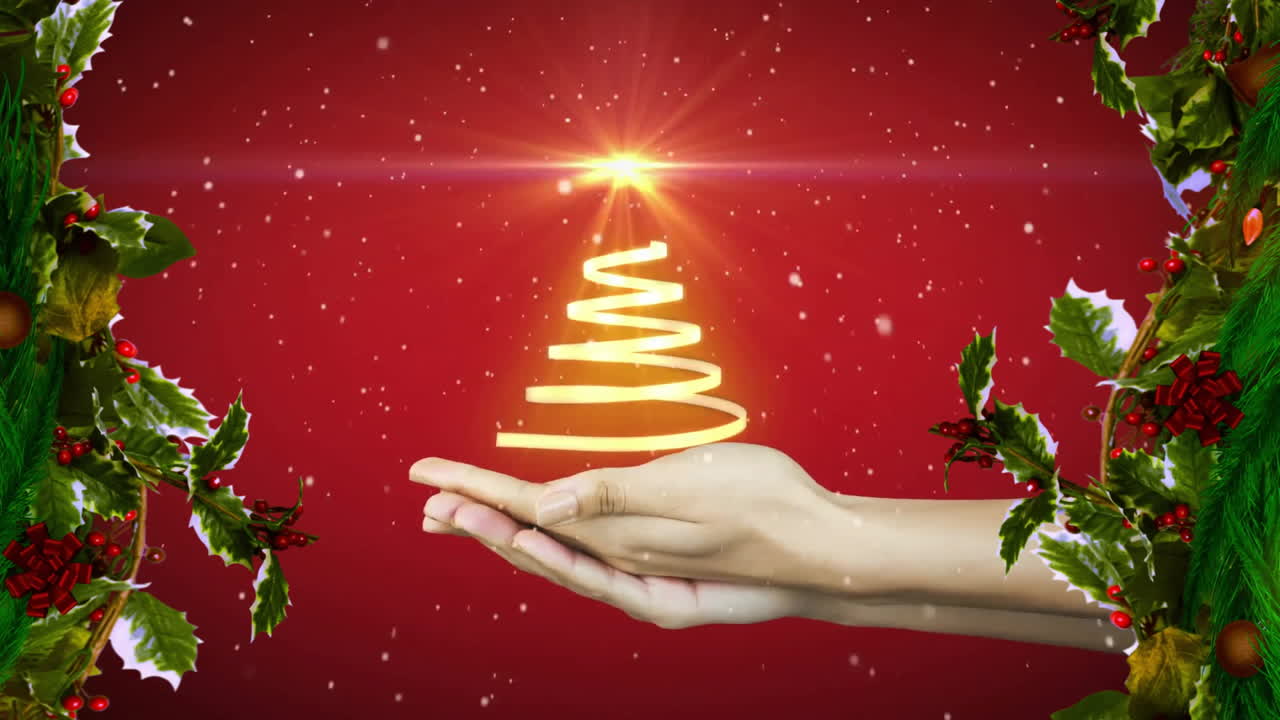 Holding glowing Christmas tree animation, hands over red background with holly decorations