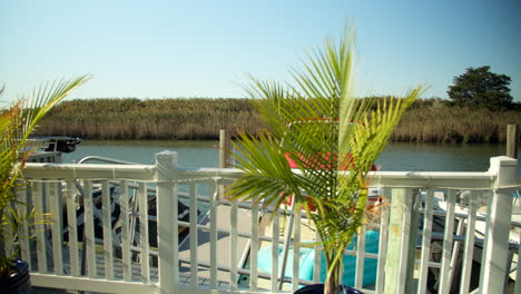 Boats-rest-in-Bay-Past-Fence-on-Deck-of-New-Jersey-Bay