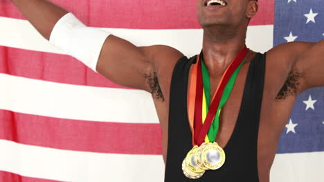 happy athlete with medals holding american flag and cheering