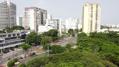 Drones-Volando-Sobre-El-Parque-Iberoamericano-De-Santo-Domingo-Con-Vistas-A-Edificios-Altos-En-El-Fondo,-Zona-Residencial-De-Clase-Media-Alta