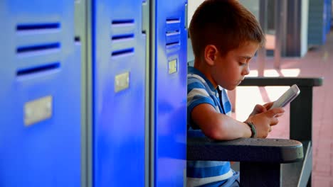 Schoolboy-using-mobile-phone-in-locker-room-4k