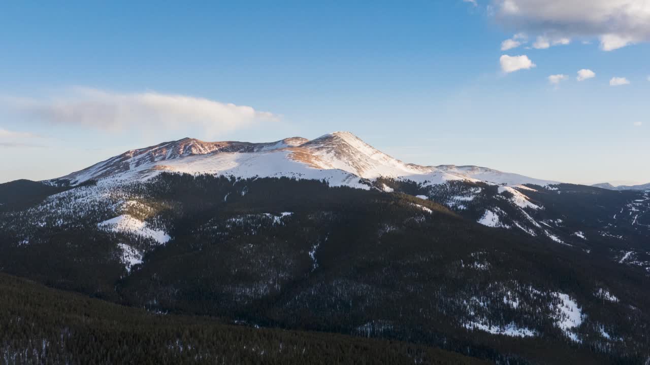Aerial pan shot of snow topped mountain in Breckenridge, Colorado of USA against blue sky. TImelapse view.