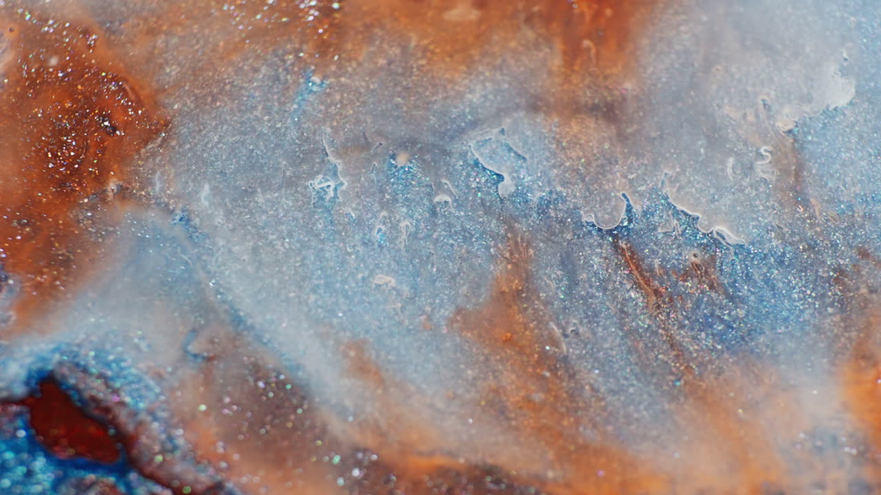 Drop of dense colourful ink mixing with water. Macro view