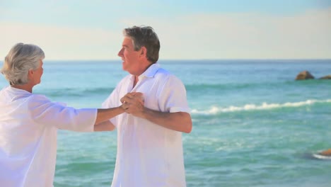 mature couple dancing on a beach