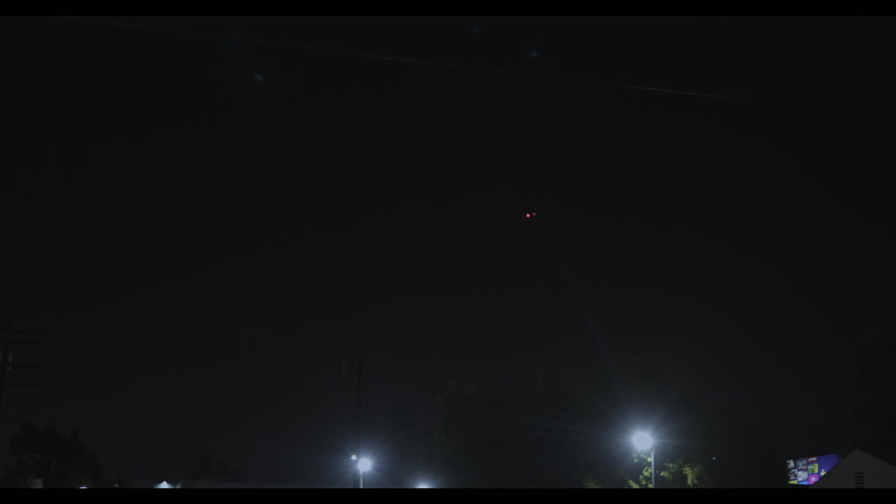 밤에 로스앤젤레스 상공을 비행하고 날개에서 빨간색과 노란색 신호를 보내는 비행기의 비디오