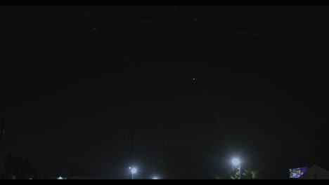 video del avion volando de noche sobre la ciudad de los angeles y señalando luces rojas y amarillas de sus alas