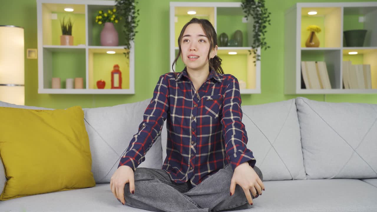 우울한 아시아 소녀가 집에서 울면서 자기 자신에게 화를 내고 있습니다.