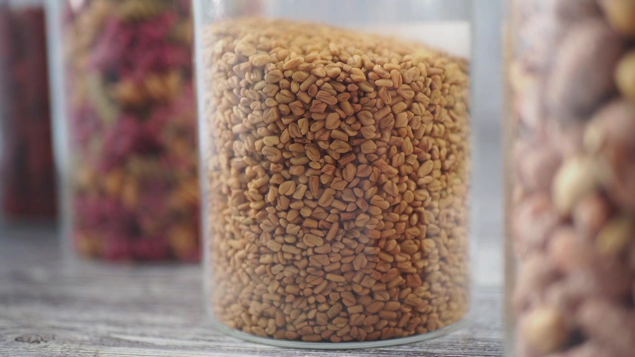 Glass Jar Filled With Fenugreek Seeds on a Wooden Surface