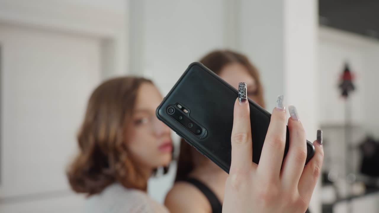 Focused Camera Shot, Closeup Of Phone With Friends Behind, Modern Portrait Capturing Friends With Smartphone Effect, Indoor Image Of Smartphone Camera Focusing On Friends With Playful Expressions