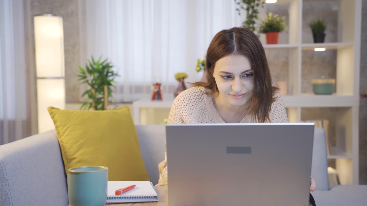mujer freelancer trabajando en una computadora portátil en la sala de estar en casa.