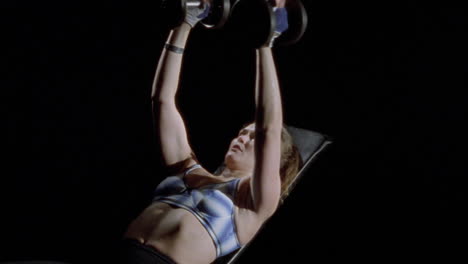 a woman exercises with dumbbells 1